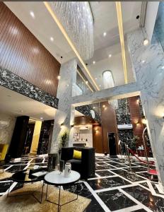 een lobby met een kroonluchter en tafels in een gebouw bij بالم السكنية in Abha
