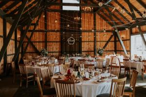 a banquet hall with tables and chairs and lights at Brīvdienu māja "Avotiņš" in Līvāni