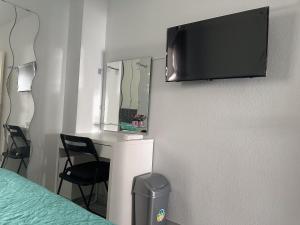Zimmer mit einem Schreibtisch und einem TV an der Wand in der Unterkunft Torremolinos habitaciones privada en apartamentos compartidos in Torremolinos