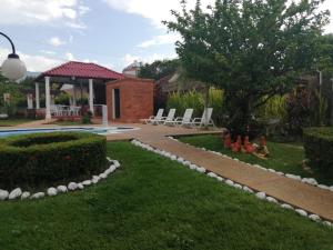 un jardin avec des chaises et un kiosque dans l'établissement Finca la SHAROLA, à Melgar