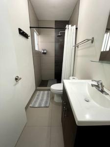 ein Bad mit einem Waschbecken, einem WC und einer Dusche in der Unterkunft Home in Ensenada close to beach in Ensenada