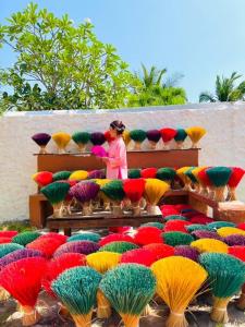 uma mulher ao lado de um monte de guarda-chuvas coloridos em Hồ Cốc Park & Resort em Xã Như Lâm