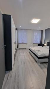 a large bedroom with a bed and a living room at CT Apartment Wurzen in Wurzen