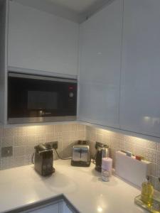 cocina con encimera, microondas y tostadora en Luxury 2Bed 2Bath City View Flat, en Londres