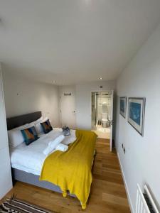 1 dormitorio con 1 cama grande con manta amarilla en Luxury 2Bed 2Bath City View Flat, en Londres