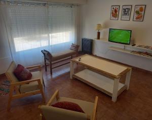 a living room with a table and a tv at Departamento dos dormitorios con cochera Tres Arroyos -2- in Tres Arroyos