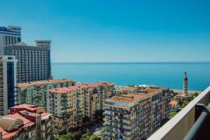 a view of a city with buildings and the ocean at Orbi apartament in Batumi