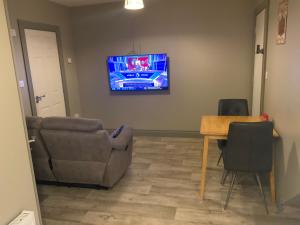 a living room with a couch and a table and a tv at Cozy small 1 bedroom apartment in Galway