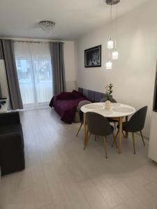 ein Wohnzimmer mit einem Tisch und ein Schlafzimmer in der Unterkunft Apartament Wierzyca in Pelplin