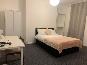 um quarto com uma cama, uma mesa e uma secretária em Warren Street Guest House em Londres