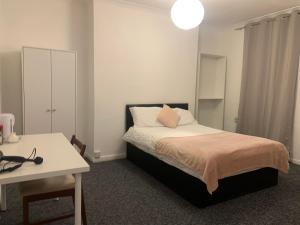um quarto com uma cama, uma mesa e uma secretária em Warren Street Guest House em Londres