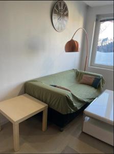 a small bed in a room with a clock on the wall at Maisonnette les fabrettes in Marseille
