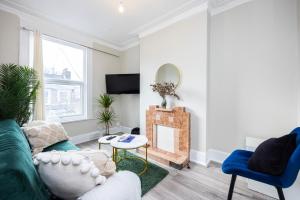a living room with a couch and a fireplace at Spacious 3 BR Near Walthamstow Station - 10 Min Walk in London