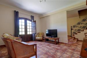 een woonkamer met een televisie en een tafel bij Quinta Azul in Moncarapacho