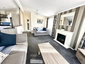 ein Wohnzimmer mit einem Sofa und einem Kamin in der Unterkunft Bluebell Lodge, Dog Friendly in South Cerney