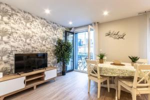 a dining room with a television and a table with chairs at El Toison 12 Parking Gratis-6 Pax Centro Histórico in Bilbao