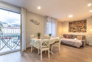 a room with a table and a bed and a balcony at El Toison 12 Parking Gratis-6 Pax Centro Histórico in Bilbao