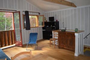 a living room with a desk and chairs in a room at La cabane du Truquet in Lège-Cap-Ferret