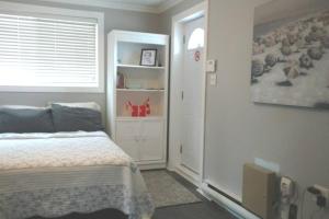 a small bedroom with a bed and a window at Sunset Cottage, 3 min walk to beach, sleeps 7 in Lambton Shores