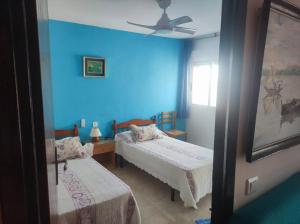 a bedroom with two beds and a blue wall at BRISA Solo FAMILIAS in Los Mártires