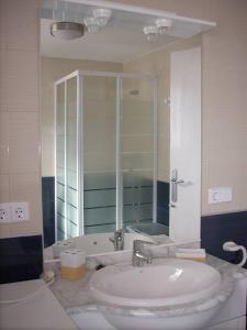 a white bathroom with a sink and a shower at BRISA Solo FAMILIAS in Los Mártires