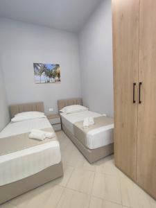 a bedroom with two beds and a closet at BP Beach Apartment in Golem