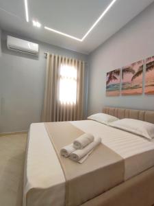 1 dormitorio con 1 cama con toallas en BP Beach Apartment en Golem