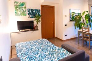 - un salon avec un canapé, une télévision et une table dans l'établissement Luminoso appartamento con giardino San Bovio, à Peschiera Borromeo