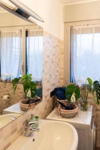 La salle de bains est pourvue d'un lavabo et d'un miroir. dans l'établissement Luminoso appartamento con giardino San Bovio, à Peschiera Borromeo