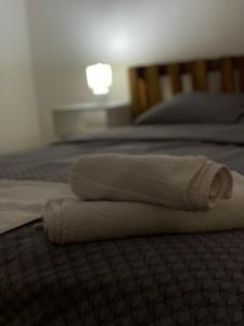 una pila de toallas sentadas en una cama en Fenix Apartman II en Zaječar