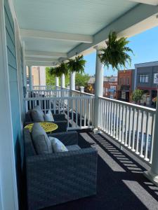 un porche con sofás y una mesa en el balcón en The Grove Hotel en Kingsville