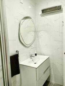 a white bathroom with a sink and a mirror at Soho Boho Apartments - with sunny rooftop terrace and fiber optic internet in Alicante