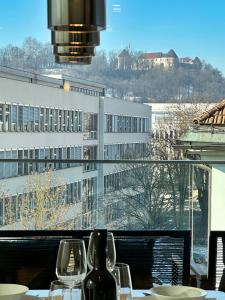 una mesa con copas de vino y vistas a un edificio en Garden Residence en Liubliana