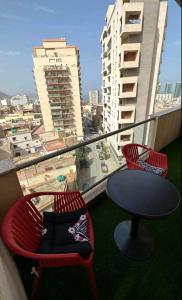 a table and chairs on a balcony with a view of a city at F4 moderne au centre ville d'oran in Oran