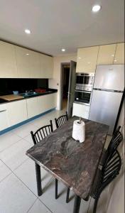 a kitchen with a table with chairs and a refrigerator at F4 moderne au centre ville d'oran in Oran