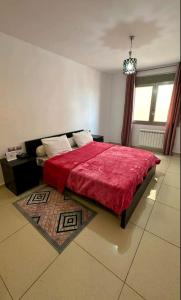 a bedroom with a red bed with a red blanket at F4 moderne au centre ville d'oran in Oran