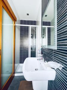 La salle de bains est pourvue d'un lavabo blanc et d'un miroir. dans l'établissement Valletta View Apartment - Wish Malta, à Sliema