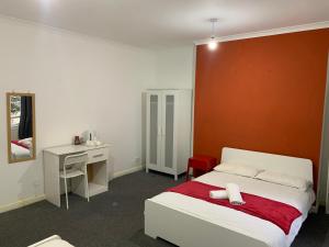a bedroom with a bed and a desk and a bed sidx sidx sidx at WARREN STREET GUEST HOUSE in London