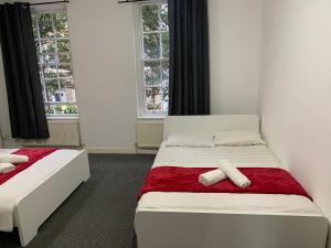 a bedroom with two beds and two windows at WARREN STREET GUEST HOUSE in London +13 photos