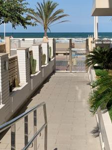 a walkway to the beach with palm trees and the ocean at BRISA Solo FAMILIAS in Los Mártires