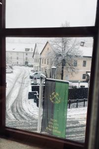 a view of a snowy street from a window at Gostišče Barbara in Idrija