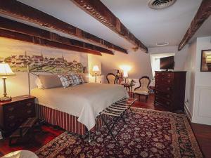 a bedroom with a large bed and a table at The Richard Johnston Inn & 1890 Caroline House in Fredericksburg