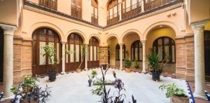 Un patio interior con plantas en macetas en un edificio. en EXCLUSIVE TRIPLEX WITH PRIVATE TERRACE, en Sevilla