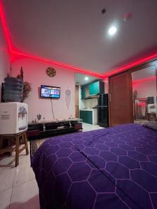 una camera con letto viola e illuminazione rossa di VR APARTMENT a Kemirimuka Dua