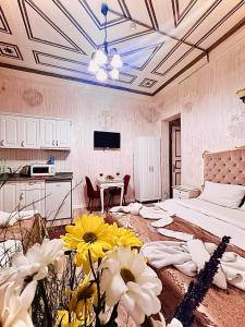 イスタンブールにあるアルハンブラ アパート ホテルのベッドと花が備わる広い客室です。
