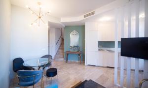 Una sala de estar con una mesa y una cocina. en EXCLUSIVE TRIPLEX WITH PRIVATE TERRACE, en Sevilla