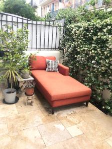 an orange couch sitting on a patio with plants at Riviera Donia House in Nice