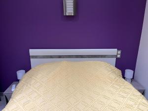 a bedroom with a bed with a purple wall at Villa chaleureuse Centre ville - Parking privée in Gap