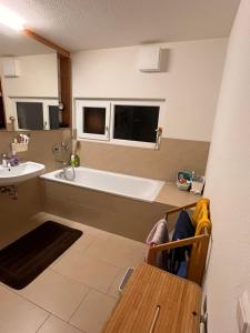 ein Badezimmer mit einer Badewanne und einem Waschbecken in der Unterkunft Großes & Modernes Ferienhaus 2 Minuten von Meersburg Innenstadt in Meersburg