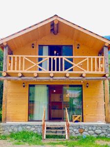 a wooden house with a balcony on top of it at Skupis kokhebi in Mestia